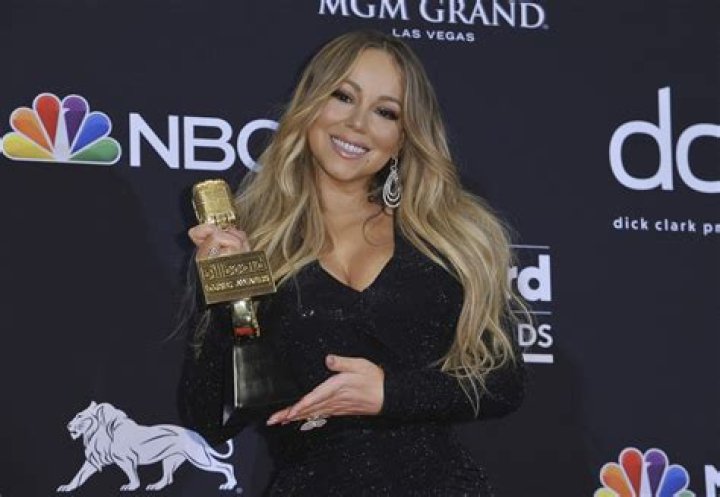 Why does Mariah Carey touch her ear?